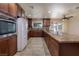 Well-lit kitchen with granite countertops, tile flooring, and dark wood cabinets and a view to the backyard at 616 Fernbrook Dr, Henderson, NV 89002
