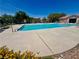 Community pool surrounded by lounging chairs and a fence for privacy at 6699 Oxendale Ave, Las Vegas, NV 89139