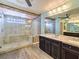 Luxurious bathroom featuring a glass-enclosed shower, marble countertop, and dark wood cabinetry for a spa-like retreat at 6779 Goose Watch Ct, Las Vegas, NV 89139