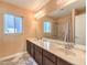 Bright bathroom featuring double sinks, a large mirror, and a shower-tub combo with marble-look surround at 6779 Goose Watch Ct, Las Vegas, NV 89139