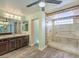 Stylish bathroom showcases a spacious shower with glass enclosure, marble countertops, and modern wood-look flooring at 6779 Goose Watch Ct, Las Vegas, NV 89139