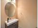 Powder room featuring modern vanity with a unique, round mirror and stylish fixture at 6779 Goose Watch Ct, Las Vegas, NV 89139