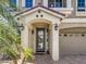 Charming front entrance with a covered porch, elegant lighting, and a well-manicured yard at 6779 Goose Watch Ct, Las Vegas, NV 89139