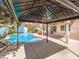 Relaxing gazebo in a private backyard oasis with a sparkling pool and lush landscaping at 6779 Goose Watch Ct, Las Vegas, NV 89139