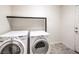Well-lit laundry room with modern, front-loading washer and dryer units at 6779 Goose Watch Ct, Las Vegas, NV 89139