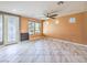 Inviting living room boasts large windows, providing ample natural light, complemented by stylish tile flooring and ceiling fan at 6779 Goose Watch Ct, Las Vegas, NV 89139
