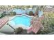 An aerial view of a backyard pool surrounded by lush greenery and flowering trees at 6779 Goose Watch Ct, Las Vegas, NV 89139