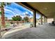 View from covered patio of the large pool, manicured lawn, and desert landscaping in the backyard at 6971 Moaning Cavern St, Las Vegas, NV 89131