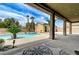 View from patio showcasing the pool, desert landscaping, palm trees, and the detached structure at 6971 Moaning Cavern St, Las Vegas, NV 89131