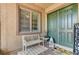 Welcoming front porch with a decorative bench, stylish welcome mat, and an attractive olive green door at 6971 Moaning Cavern St, Las Vegas, NV 89131