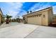 View of garage on concrete drive with a pool in the background, accented with patio lights and palm trees at 6971 Moaning Cavern St, Las Vegas, NV 89131