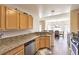Eat-in kitchen featuring wooden cabinets, granite counters, stainless appliances, and dining area with natural light at 7641 Sea Wind Dr, Las Vegas, NV 89128