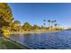 Picturesque lakeside view featuring a serene body of water and lush parkland with palm trees at 7641 Sea Wind Dr, Las Vegas, NV 89128