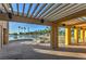 A shaded lounge area overlooks the beach with a sandy shoreline and palm trees reflecting on the water at 7641 Sea Wind Dr, Las Vegas, NV 89128