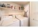 Functional laundry room with side-by-side washer and dryer and storage shelves at 7641 Sea Wind Dr, Las Vegas, NV 89128