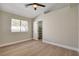 Bedroom with wood-look floors, window view, and an open door to a closet at 7805 Leavorite Dr, Las Vegas, NV 89128