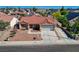 Aerial shot of well-manicured home featuring a tile roof, desert landscaping, and attached garage at 7805 Leavorite Dr, Las Vegas, NV 89128
