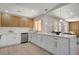 Modern kitchen featuring white countertops with gold hardware, stainless appliances, and a breakfast bar at 7805 Leavorite Dr, Las Vegas, NV 89128