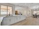 Bright kitchen with white cabinets, marble countertops and an island featuring a breakfast bar at 7805 Leavorite Dr, Las Vegas, NV 89128