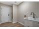 Bright laundry room with a utility sink and a door leading to the outside at 7805 Leavorite Dr, Las Vegas, NV 89128