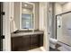 Modern bathroom with sleek vanity, stylish mirror, and glass-enclosed shower with textured wall at 787 Keyland St, Las Vegas, NV 89138