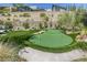 Backyard putting green with sand trap is professionally landscaped with low-maintenance synthetic turf and desert plants at 787 Keyland St, Las Vegas, NV 89138