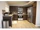 A cozy kitchen with stainless steel appliances, wood cabinets, and light wood flooring at 837 Holly Lake Way, Henderson, NV 89002