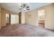 Large bedroom featuring ceiling fan, carpeted floor, and bathroom and closet access at 89 Autumn Day St, Henderson, NV 89012
