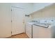 Neat laundry room featuring modern washer and dryer units, overhead shelving, and a white entry door at 89 Autumn Day St, Henderson, NV 89012