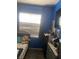 This bedroom has blue walls, a large window with blinds, a wood floor and several shelves at 8913 Cambridge Glen Ct, Las Vegas, NV 89149