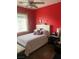 Comfortable bedroom with bright red walls, a cozy bed, and natural light at 8913 Cambridge Glen Ct, Las Vegas, NV 89149