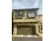 Two story townhouse with a two car garage and decorative window safety bars at 8913 Cambridge Glen Ct, Las Vegas, NV 89149