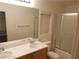 Bathroom with double sinks, mirror, and a shower with glass doors at 8982 Leaping Pad Ct, Las Vegas, NV 89148