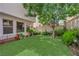 This backyard features beautiful foliage, artificial grass, and a bench for relaxation at 9082 Amanda Creek Ct, Las Vegas, NV 89149