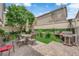 This backyard features an outdoor seating area, grill, beautiful landscaping, and a lush tree at 9082 Amanda Creek Ct, Las Vegas, NV 89149