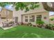 The backyard features an outdoor dining area, manicured lawn, and beautiful foliage at 9082 Amanda Creek Ct, Las Vegas, NV 89149