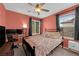 Bedroom with a pink accent wall, bed, ceiling fan, and desk at 9082 Amanda Creek Ct, Las Vegas, NV 89149