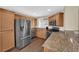 Well-lit kitchen with wood cabinets, granite countertops, and stainless steel appliances at 9082 Amanda Creek Ct, Las Vegas, NV 89149