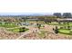 Aerial view of a golf course, with a pond, trees, desert, and hotel in the background at 9125 Las Manaitas Ave # 302, Las Vegas, NV 89144