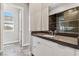 Stylish bathroom vanity with dark countertop, modern fixtures, and a view of the glass-enclosed shower at 9125 Las Manaitas Ave # 302, Las Vegas, NV 89144