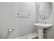 Bathroom features a pedestal sink, round mirror, and towel rack at 9125 Las Manaitas Ave # 302, Las Vegas, NV 89144