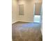 Interior view of a bedroom with gray carpet, light grey walls, white trim, windows and sliding glass doors at 9125 Las Manaitas Ave # 302, Las Vegas, NV 89144