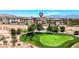 Aerial view showing luxury condominiums overlooking a pristine golf course with a mountain backdrop at 9125 Las Manaitas Ave # 302, Las Vegas, NV 89144