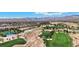 Expansive aerial view of a golf course, with multiple greens and bunkers, set against a mountainous backdrop at 9125 Las Manaitas Ave # 302, Las Vegas, NV 89144