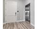 Hallway featuring an entrance door with keypad, stainless steel elevator, and wood-look floors at 9125 Las Manaitas Ave # 302, Las Vegas, NV 89144