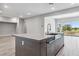 Open-concept kitchen island with stainless steel sink and dishwasher, flowing into a brightly lit living space at 9125 Las Manaitas Ave # 302, Las Vegas, NV 89144