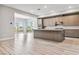 Spacious kitchen and living room with a large island, modern cabinets, and sliding glass doors to the balcony at 9125 Las Manaitas Ave # 302, Las Vegas, NV 89144