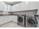 Laundry room with a sink, cabinets, and two modern washing machines at 9125 Las Manaitas Ave # 302, Las Vegas, NV 89144