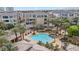 Beautiful aerial view of the community pool, resort-style landscaping, and multi-story buildings at 9125 Las Manaitas Ave # 302, Las Vegas, NV 89144