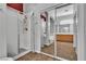 Bright bathroom featuring walk-in shower and vanity with wood cabinets, and tub in mirror reflection at 9362 Wilderness Glen Ave, Las Vegas, NV 89178